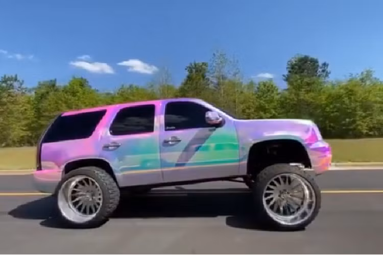 Yếu tố đầu tiên sẽ khiến người nhìn lập tức để ý là lớp vỏ bọc 7 sắc cầu vồng ngoài ngoại thất và thực sự khiến chiếc GMC Yukon trông như bước ra từ một trò chơi điện tử. Tiếp theo, bộ la-zăng độ khổng lồ càng khiến nó trở nên nổi bật trên đường phố.