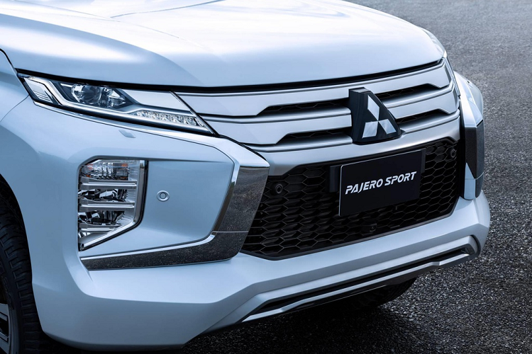 Đầu xe của Pajero Sport 2020 là nơi thay đổi rõ rệt nhất. Lưới tản nhiệt được làm dày hơn với 3 nan ngang to bản. Cụm đèn pha bi-LED tích hợp đèn daylight được vuốt mảnh đặt phía trên. Cụm đèn 3 tầng gồm đèn sương mù và đèn chiếu gần đặt bên dưới. Kiểu bố trí đèn này tương tự Xpander và Triton. 