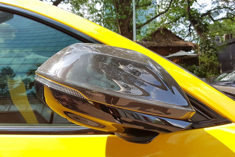 Cận cảnh gương xe ốp carbon, logo Mansory với đường line vàng chạy ngang