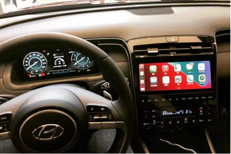 Hyundai loại bỏ cần số truyền thống trên Tucson 2021 và các nút bấm của hệ thống điều hoà, thay vào đó là các phím điều khiển hiện đại hơn. Xe hỗ trợ Apple CarPlay và Android Auto cũng như cho phép kết nối Bluetooth 2 thiết bị cùng lúc. Bao quanh khu vực táp lô và bảng điều khiển trung tâm là 2 dải trang trí bạc đẹp mắt. Các khe thông gió mỏng kéo dài được vuốt theo dải trang trí này. Ngồi trên xe Hyundai Tucson 2021, chủ xe có thể điều khiển một số thiết bị nội thất thông minh tại nhà, như đèn đóm và điều hòa.