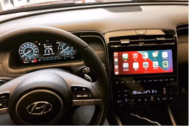 Hyundai loại bỏ cần số truyền thống trên Tucson 2021 và các nút bấm của hệ thống điều hoà, thay vào đó là các phím điều khiển hiện đại hơn. Xe hỗ trợ Apple CarPlay và Android Auto cũng như cho phép kết nối Bluetooth 2 thiết bị cùng lúc. Bao quanh khu vực táp lô và bảng điều khiển trung tâm là 2 dải trang trí bạc đẹp mắt. Các khe thông gió mỏng kéo dài được vuốt theo dải trang trí này. Ngồi trên xe Hyundai Tucson 2021, chủ xe có thể điều khiển một số thiết bị nội thất thông minh tại nhà, như đèn đóm và điều hòa.