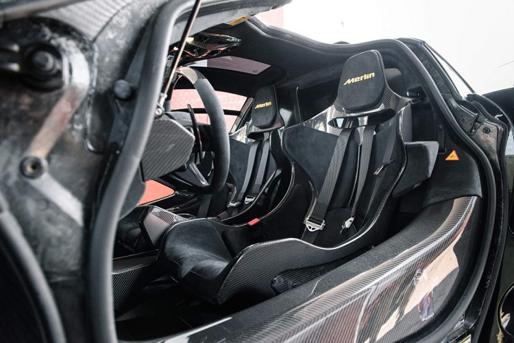 Khoang nội thất của Senna Merlin rất đơn giản với phong cách phối giữa các chi tiết carbon cùng những đường màu gold. Điều đặc biệt nhất trong khoang nội thất nằm ở phần bàn đạp với họa tiết trăng và sao được khắc laser đầy nổi bật, hợp nhất với phong cách “ma mị” của phiên bản cũng như truyền thuyết về Merlin. Trên bậc cửa ốp carbon, một họa tiết tạo hình pháp sư Merlin đã được trang bị làm cho phiên bản thêm phần độc đáo.