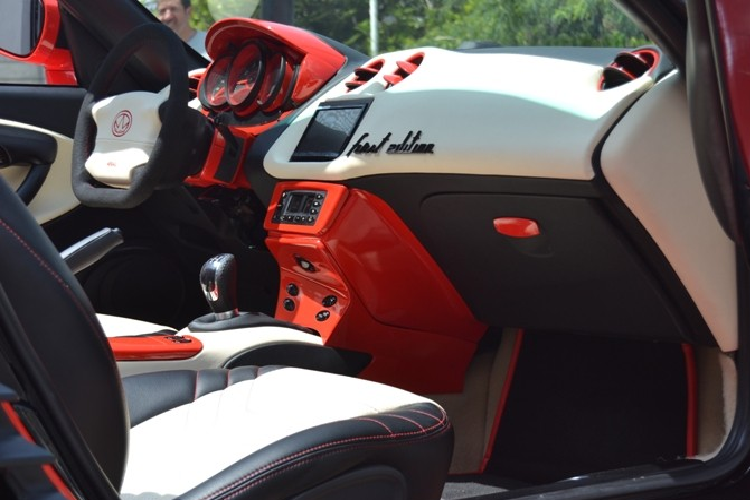 Không chỉ tiến hành “làm thẩm mỹ” phía trước, chiếc Porsche Boxster tiếp tục nhận được các trang bị độ nhằm thay đổi diện mạo ở phía bên sườn với bộ la-zăng màu đỏ và cửa tự sát kiểu Lamborghini.