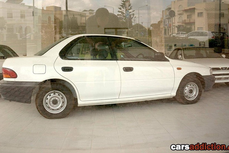 Tiếp đến là một chiếc Subaru Legacy màu đỏ đậm, có vẻ là xe đã qua sử dụng. Thêm vào đó là sự hiện diện của một chiếc Volkswagen Beetle màu đỏ bị mất một số bộ phận ngoại thất.