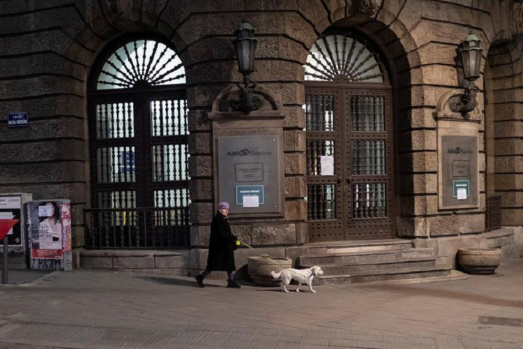 Một người phụ nữ dắt chó đi dạo trong giờ giới nghiêm ở Belgrade, Serbia, ngày 23/3. 