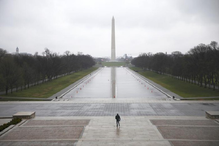 Một người đàn ông đi bộ trong National Mall ở Washington vào ngày 15/3. 
