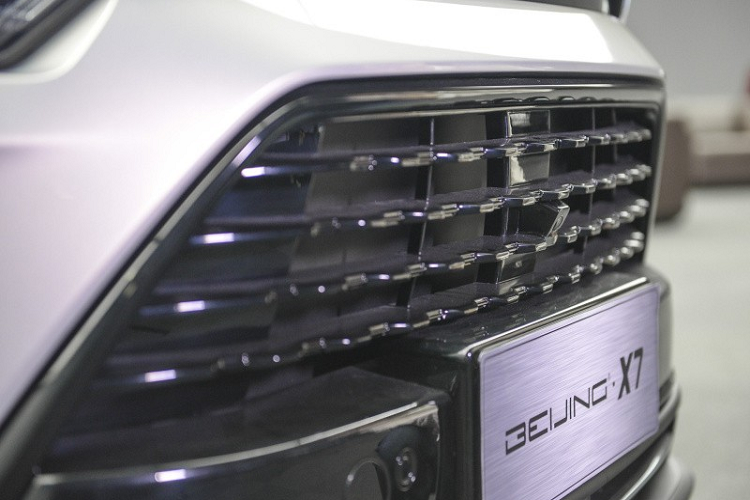 Trên đầu xe, Beijing X7 được trang bị lưới tản nhiệt hình thang cỡ lớn với những chấm nhỏ mạ crôm dạng ma trận... và cụm đèn pha LED toàn phần. Nối giữa 2 cụm đèn pha là thanh mạ crôm nằm sát với nắp ca-pô. Chưa hết, giữa nắp ca-pô và lưới tản nhiệt còn có một dải màu đen bóng khiến người ta tưởng đây là khe gió nếu chỉ nhìn thoáng qua.