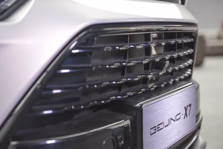 Trên đầu xe, Beijing X7 được trang bị lưới tản nhiệt hình thang cỡ lớn với những chấm nhỏ mạ crôm dạng ma trận... và cụm đèn pha LED toàn phần. Nối giữa 2 cụm đèn pha là thanh mạ crôm nằm sát với nắp ca-pô. Chưa hết, giữa nắp ca-pô và lưới tản nhiệt còn có một dải màu đen bóng khiến người ta tưởng đây là khe gió nếu chỉ nhìn thoáng qua.