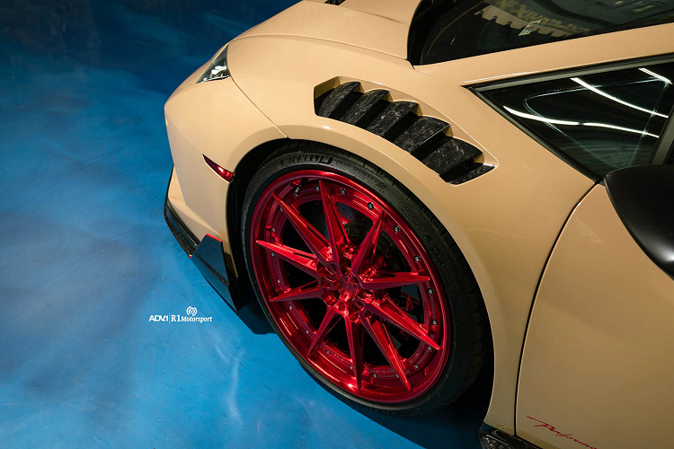 Bản độ Lamborghini Huracan Performante khoác lên mình màu sơn mới được lấy cảm hứng từ những triền cát trên sa mạc. Không quá phô trương, cũng không quá phổ thông, màu sơn này có lẽ sẽ làm hài lòng đa số khách hàng. Chiếc siêu xe được trang bị bộ body kit với phần líp cản trước mới, nẹp hông màu đen lạ mắt, đặc biệt chắn bùn phía trước nổi bật hơn với những đường cắt táo bạo. Nắp capo độc đáo với 2 khe gió mới cũng là điểm nhấn trên bản độ này.