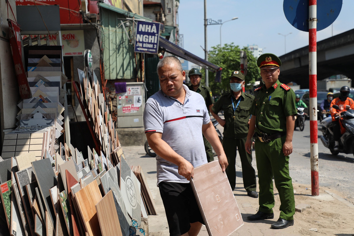 “Trong thời gian tới, các lực lượng chức năng phường Hạ Đình sẽ tăng cường kiểm tra, xử lý nghiêm các vi phạm về trật tự văn minh đô thị, trật tự an toàn giao thông và vệ sinh môi trường các tuyến phố trên địa bàn để tạo sức răn đe, ngăn chặn hành vi tái vi phạm”, ông Bùi Việt Nga nhấn mạnh. Ảnh: Hộ kinh doanh vi phạm đang thu dọn, trả lại diện tích vỉa hè bị lấn chiếm. 
