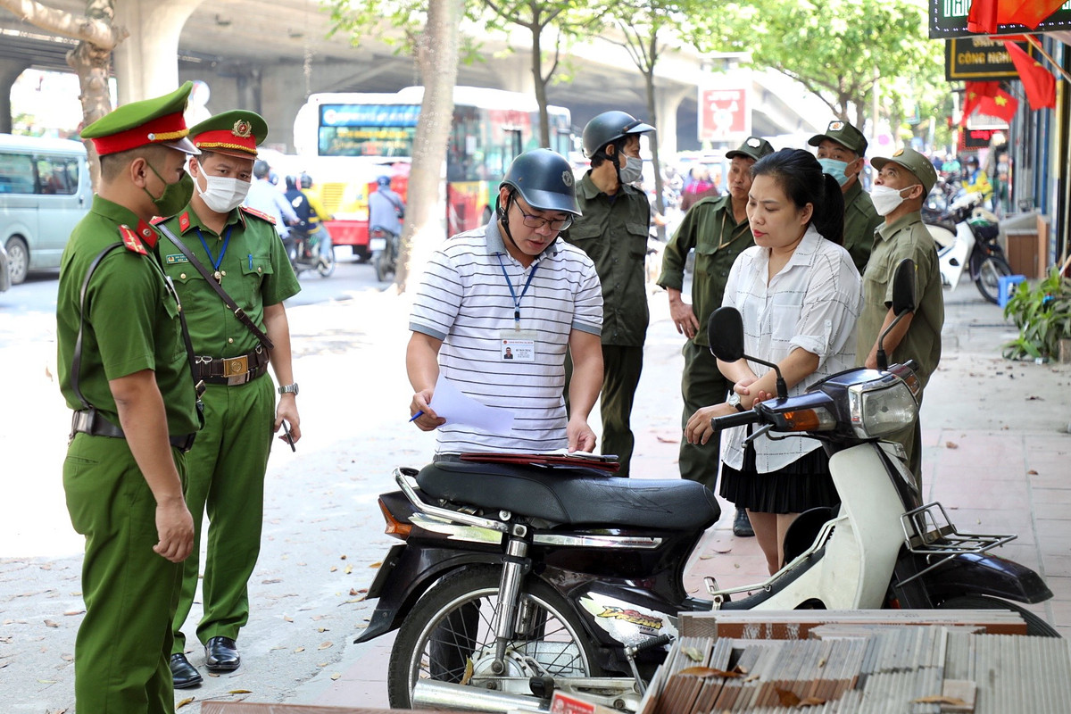 Ông Bùi Việt Nga - Phó Chủ tịch UBND phường Hạ Đình cho biết, thời gian qua UBND phường, công an phường thường xuyên kiểm tra, xử lý những trường hợp vi phạm vỉa hè. Tuy nhiên, khi lực lực lượng tuần tra vắng mặt thì vẫn có trường hợp tái vi phạm, nguyên nhân do sự thiếu ý thức tuân thủ pháp luật từ một số chủ hộ kinh doanh. Ảnh: Hộ kinh doanh vi phạm lấn chiếm vỉa hè bị lực lượng chức năng lập biên bản xử lý.