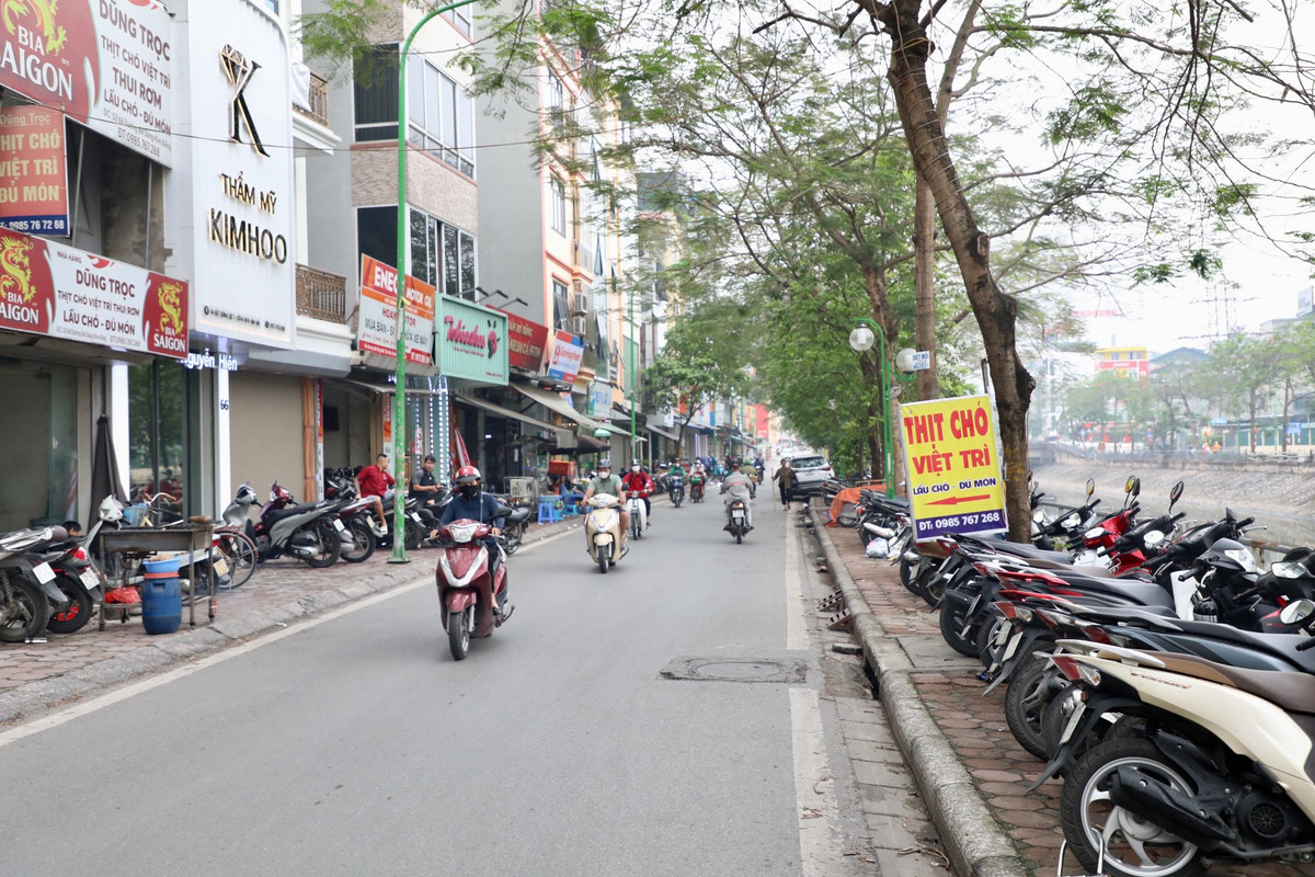 Tại đường bờ sông Sét (phường Tân Mai, quận Hoàng Mai) hàng loạt quán ăn bày bán cùng hàng dài ô tô, xe máy lấn chiếm hết phần vỉa hè.