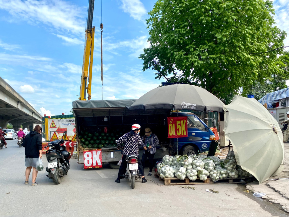Việc người dân dừng xe mua các mặt hàng được bày bán dưới lòng đường còn tiềm ẩn nguy cơ tai nạn giao thông.