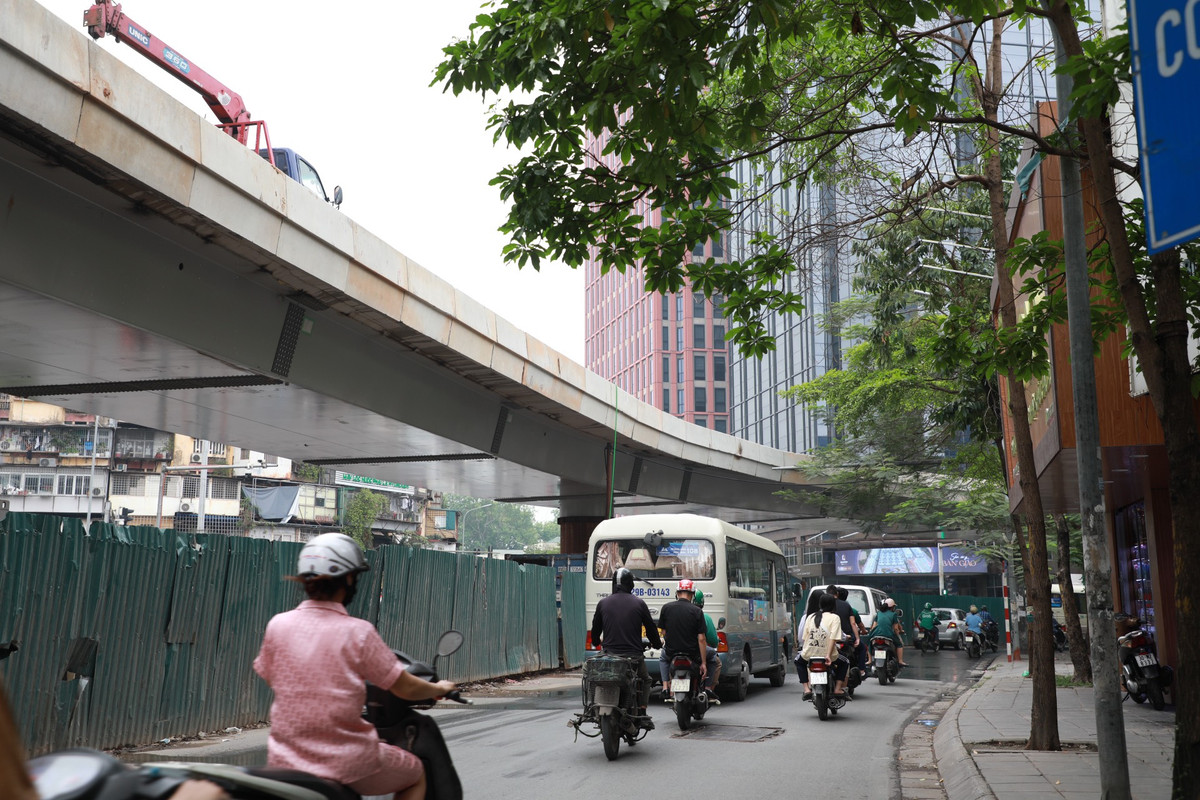 Phần phía dưới cầu cơ bản hoàn thiện, chờ trồng thêm hoa trang trí. Công nhân cũng đang tháo dần các rào chắn bằng tôn, hoàn trả mặt đường.