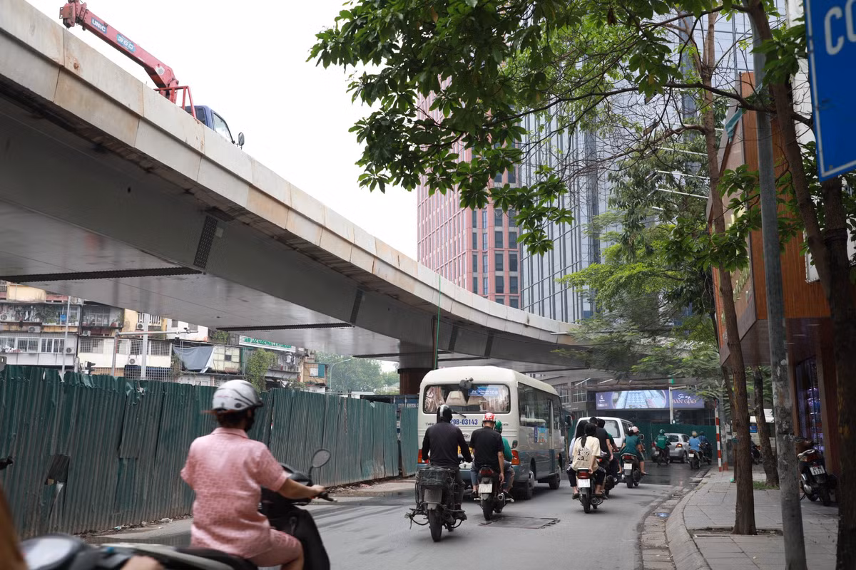 Phần phía dưới cầu cơ bản hoàn thiện, chờ trồng thêm hoa trang trí. Công nhân cũng đang tháo dần các rào chắn bằng tôn, hoàn trả mặt đường.