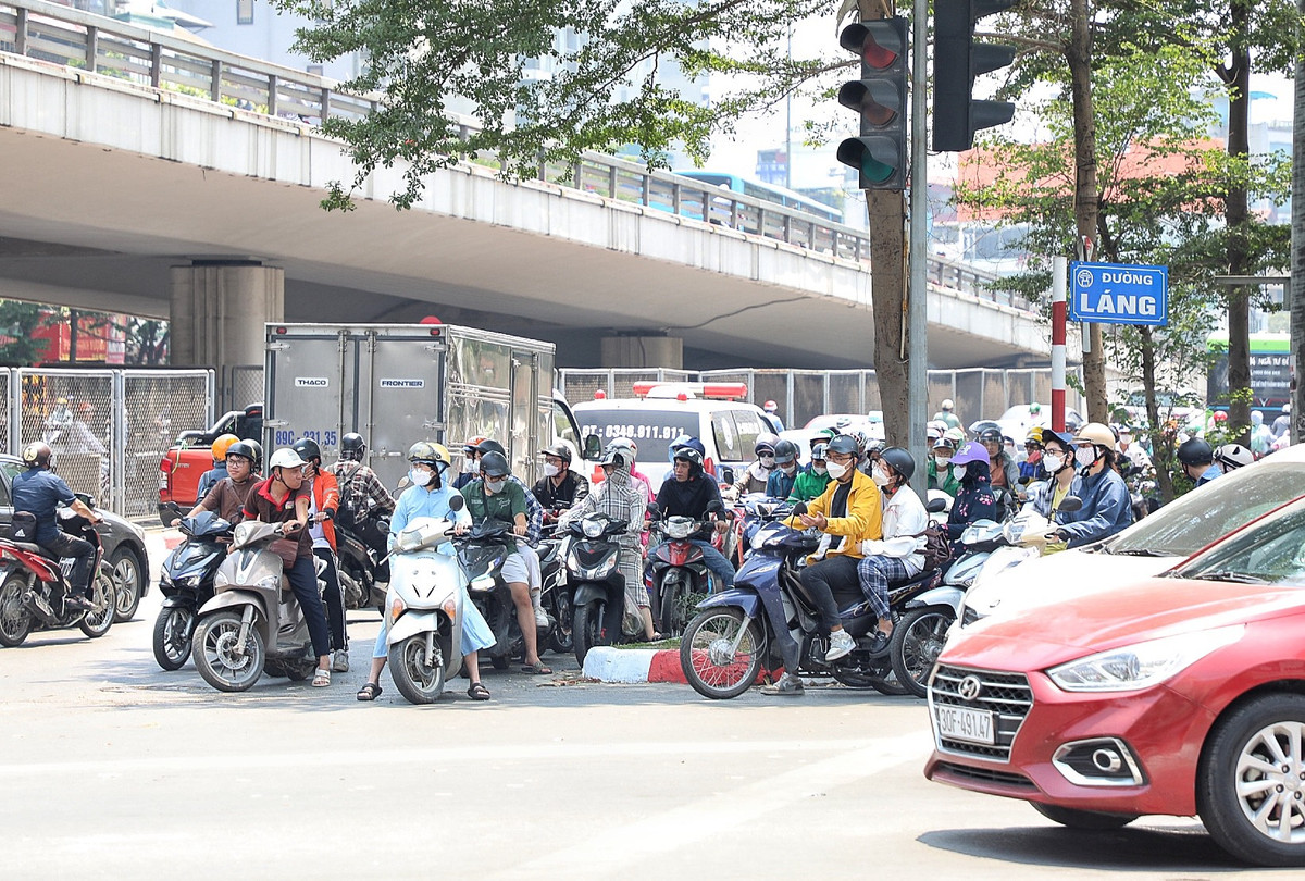 Nắng nóng khiến người tham gia giao thông bất chấp nguy hiểm tập trung chờ đèn đỏ dưới bóng cây râm mát.