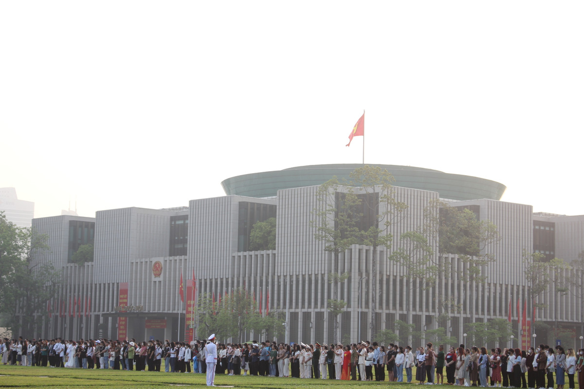 Trên Quảng trường Ba Đình, người dân dừng mọi hoạt động, nghiêm trang chuẩn bị dự lễ chào cờ.