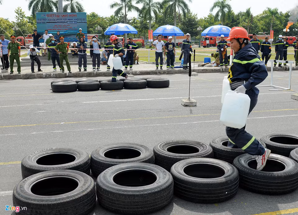 Cảnh sát trong phần thi xách nước vượt chướng ngại vật dập lửa.