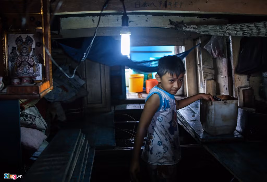 Bé Trần Duy Khang (9 tuổi) múc nước từ trong ghe ra ngoài sau một cơn mưa lớn. Thời gian nghỉ hè em chỉ loanh quanh giúp ba mẹ việc nhà.