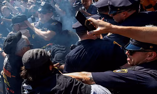 Cảnh sát Mỹ ngăn cản các thành viên của “Đảng Cộng sản Cách mạng, Mỹ” (RCP, USA) bên ngoài cổng Đấu trường Quicken Loans, khu vực diễn ra Đại hội toàn quốc Đảng Cộng hòa hôm 20/7.