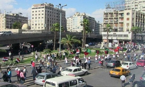 Đường phố tấp nập với xe cộ và con người ở Damascus.