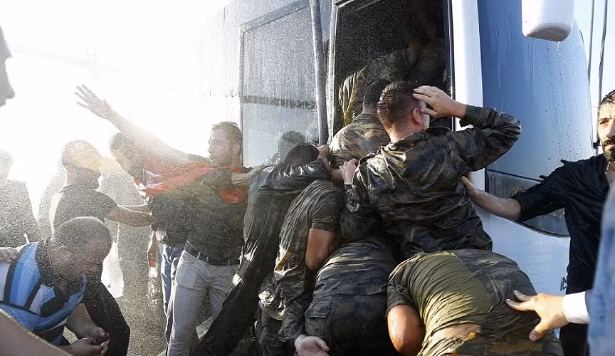 Các binh sĩ đảo chính bị đưa lên một chiếc xe buýt sau khi bị cảnh sát và người dân bắt giữ.