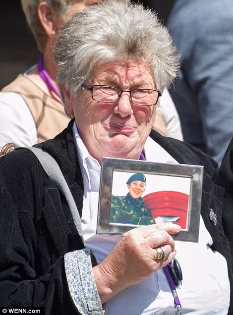 Dawn Holmes, mẹ của quân nhân Sarah Holmes, bật khóc khi cầm bức ảnh chụp con trai bà hồi còn sống.