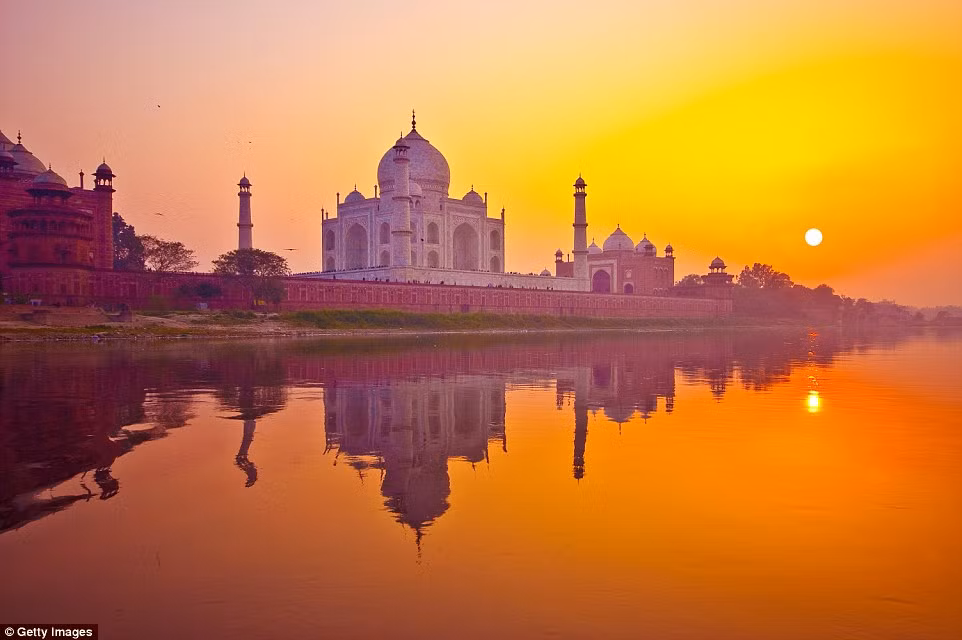  Cảnh hoàng hôn đẹp mê hồn ở lăng Taj Mahal của Ấn Độ. Ánh nắng mặt trời cuối ngày phản chiếu xuống mặt nước hồ thành một màu da cam kỳ lạ.