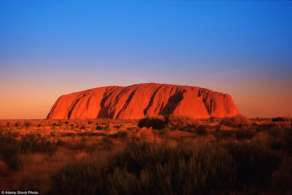 Đá Ayers, một khối kiến tạo sa thạch ở Australia, đỏ rực khi hoàng hôn buông xuống.