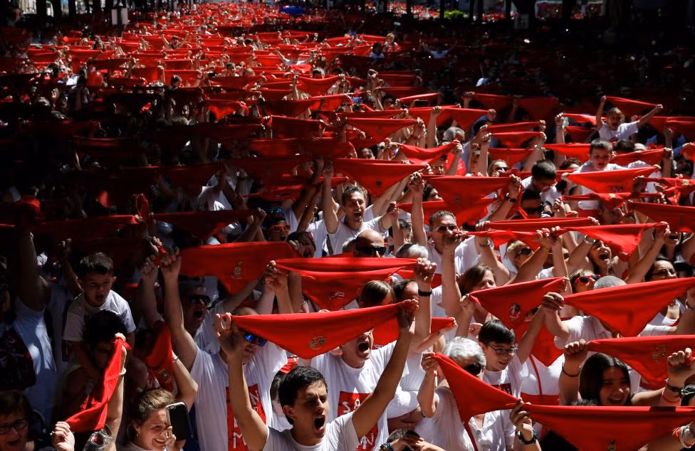 Những người tham dự cầm chiếc khăn màu đỏ trên đường phố Paseo Sarasate khi lễ hội bắt đầu ngày 6/7.