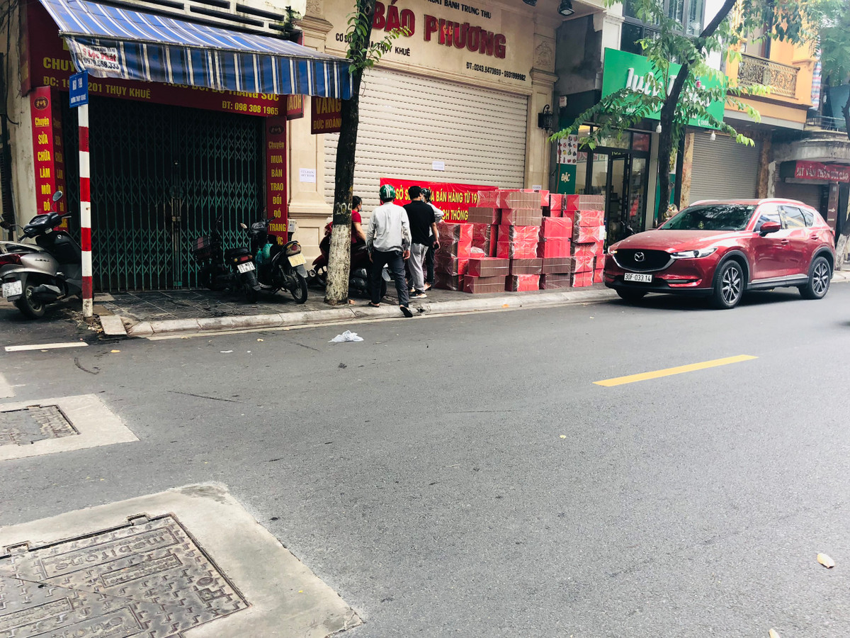 Ghi nhận của PV báo Tri thức và Cuộc sống, chiều 17/9, dù đang buộc phải đóng cửa, tạm dừng kinh doanh nhưng cửa hàng bánh Trung thu Bảo Phương vẫn hoạt động với việc "lén lút" mở hé cửa để bán cho những người đặt trước hoặc xuất hàng theo hình thức nhận đặt - giao hàng tại nhà.
