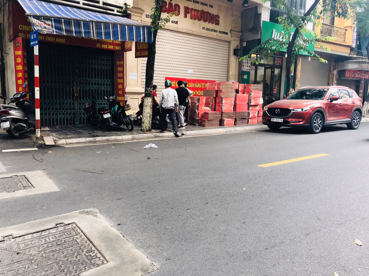 Ghi nhận của PV báo Tri thức và Cuộc sống, chiều 17/9, dù đang buộc phải đóng cửa, tạm dừng kinh doanh nhưng cửa hàng bánh Trung thu Bảo Phương vẫn hoạt động với việc "lén lút" mở hé cửa để bán cho những người đặt trước hoặc xuất hàng theo hình thức nhận đặt - giao hàng tại nhà.