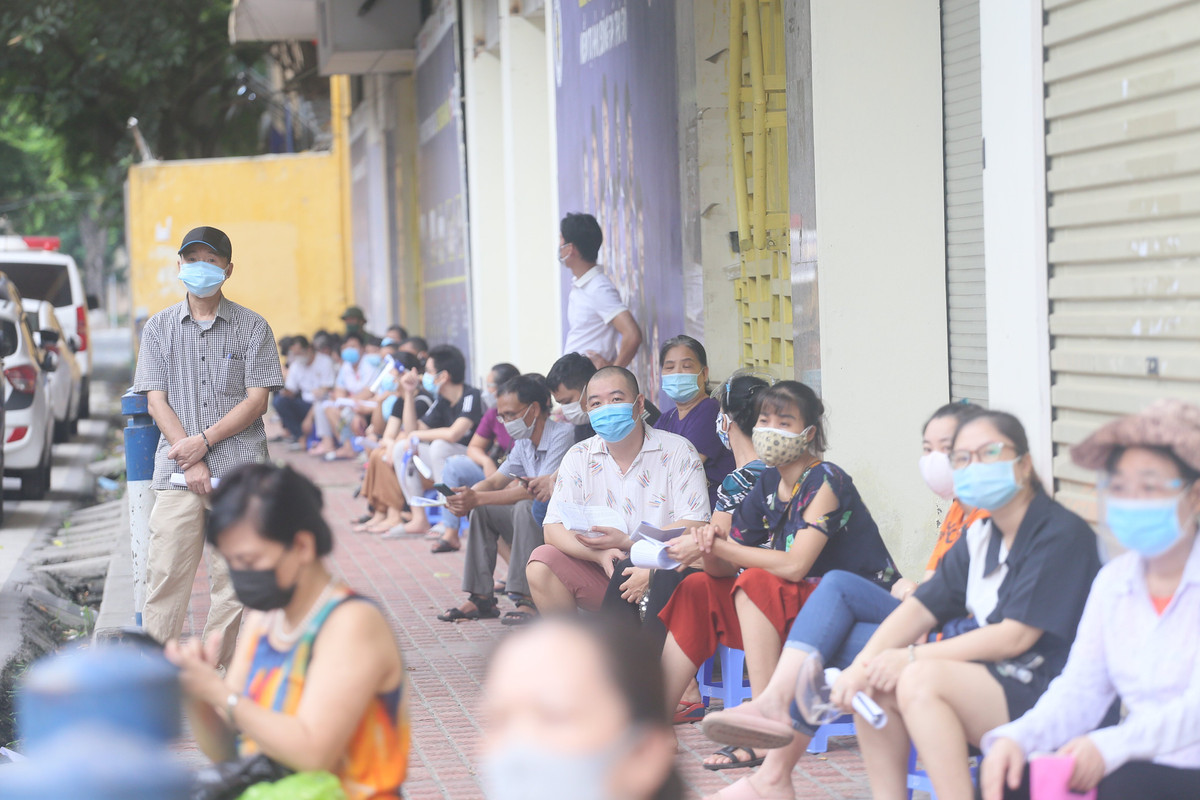 Trước khi đến lượt làm thủ tục tiêm vắc , người dân đến đây được hướng dẫn xếp hàng giãn cách theo đúng quy định phòng chống dịch.