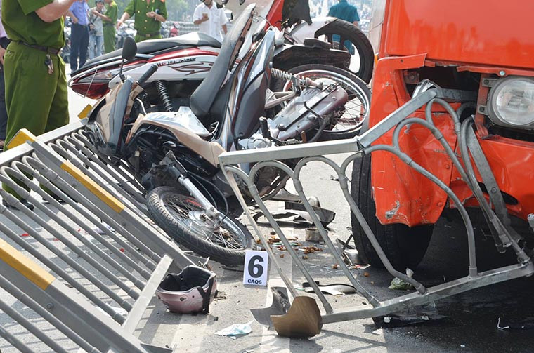 Xe Phương Trang tông 7 xe máy khiến 10 mét rào dải phân cách bị húc tung, nhiều xe máy bị cuốn vào gầm, số còn lại nằm lăn lóc trên cầu.
