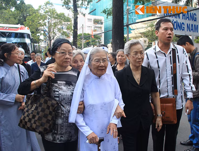 Người phụ nữ nhỏ nhắn này chống gậy đi bộ cùng đoàn xe tang từ nhà tang lễ ra đến đường Điện Biên Phủ để đưa tiễn chồng.