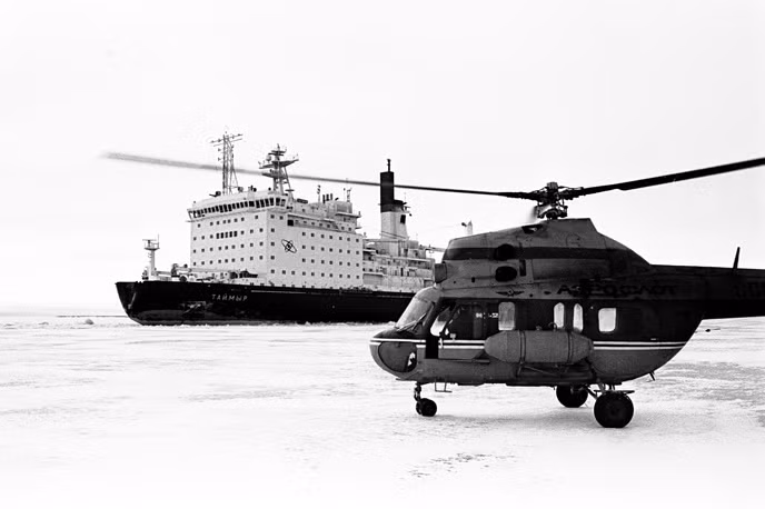 Hạm đội này bao gồm 4 tàu phá băng nguyên tử và 4 tàu dịch vụ hậu cần. Trong ảnh: Tàu phá băng nguyên tử Taimyr và trực thưang Mi-2 trên Cực Bắc. Nguồn ảnh: Tass.