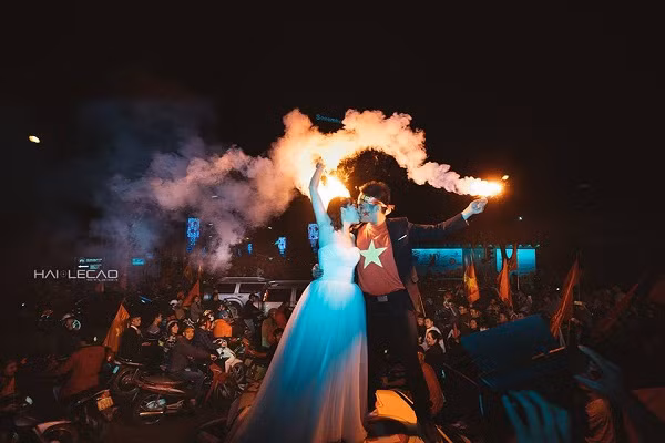 Cả hai trao nhau nụ hôn giữa đám đông cổ động viên đang reo hò.