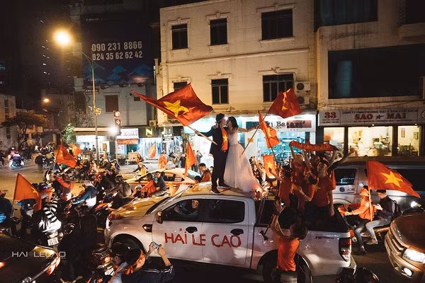 Ngay sau đó, cặp đôi diễu hành trên phố Hà Nội, hòa vào dòng người người hâm mộ đổ ra đường cổ vũ U23 Việt Nam, để thực hiện bộ ảnh cưới "lịch sử" của riêng mình.