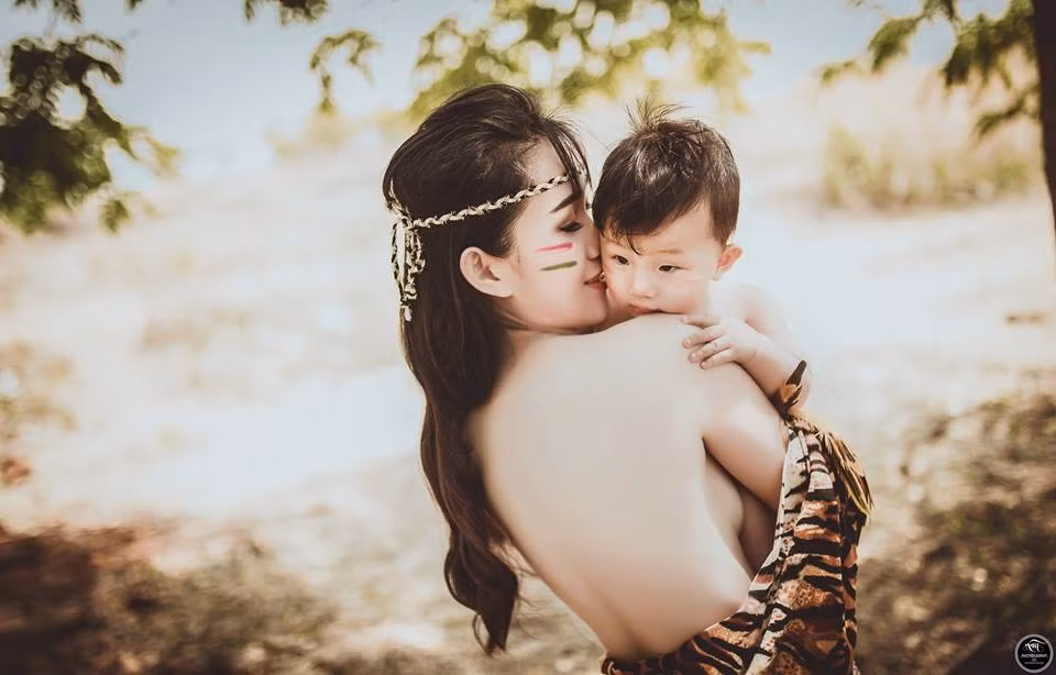 Có lẽ, tình mẫu tử luôn là thứ tình cảm thiêng liêng nhất của nhân loại. Vậy nên những đề tài liên quan đến tình mẹ con luôn dễ dàng chiếm được cảm tình trọn vẹn từ cộng đồng mạng. Trong một vài ngày qua, những bức ảnh của một người phụ nữ trẻ trong trang phục thổ dân, trên tay ẵm đứa con nhỏ, dịu dàng vuốt ve cậu con trai bé bỏng đang gây được sự chú ý lớn của mọi người. Ảnh: Tài Linh Art.