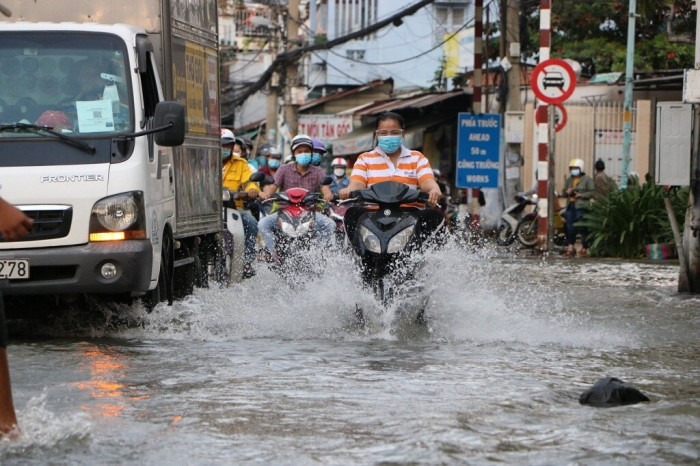 Nhiều đoạn ngập sâu gần nửa bánh xe máy, có nơi ngập sâu hơn nửa bánh xe, nhiều người cố gắng vượt dòng nước trên đường Trần Xuân Soạn để về nhà.