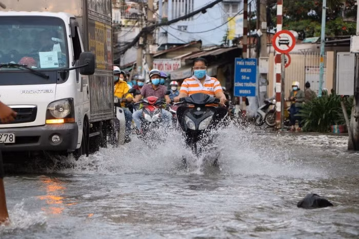 Nhiều đoạn ngập sâu gần nửa bánh xe máy, có nơi ngập sâu hơn nửa bánh xe, nhiều người cố gắng vượt dòng nước trên đường Trần Xuân Soạn để về nhà.