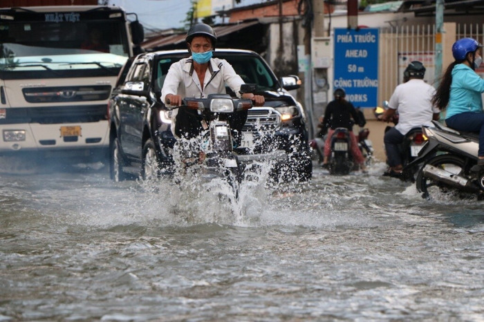 Nhiều người đi xe máy cố vặn ga để chạy thật nhanh qua chỗ ngập. Xe container cố gắng chạy chậm nhưng cũng tạo thành những sóng nước hất vào những người đi xe máy. Nhiều người chạy loạng choạng, va chạm vào các xe khác trên đoạn đường ngập.