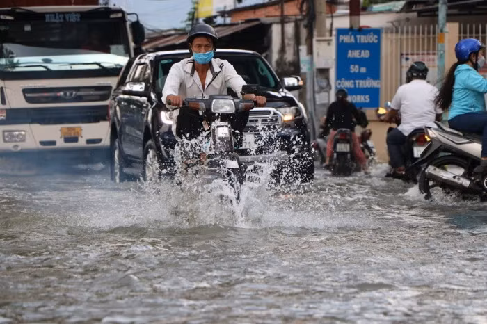 Nhiều người đi xe máy cố vặn ga để chạy thật nhanh qua chỗ ngập. Xe container cố gắng chạy chậm nhưng cũng tạo thành những sóng nước hất vào những người đi xe máy. Nhiều người chạy loạng choạng, va chạm vào các xe khác trên đoạn đường ngập.