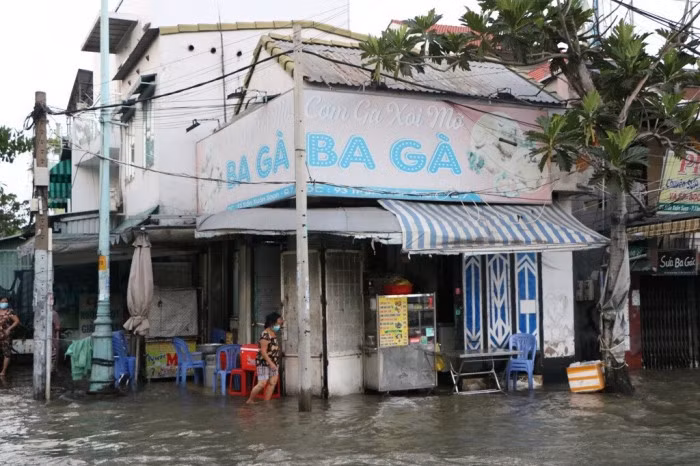 Nước ngập tràn vào quán sá, người dân phải tát nước ra bên ngoài, cuộc sống kinh doanh của người dân trên tuyến đường này bị đảo lộn.