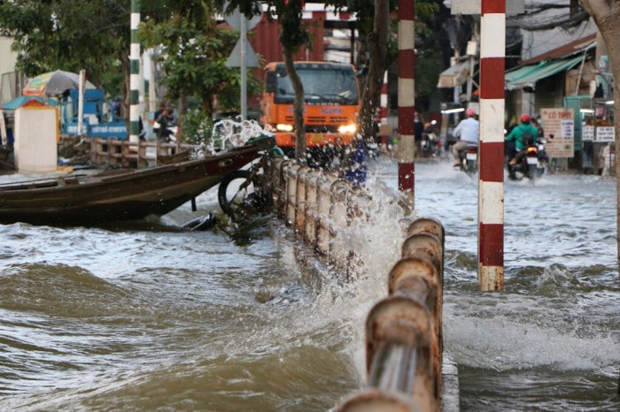 Theo ghi nhận của PV Báo Giao thông, từ hơn 16h30 nước dâng lên rất cao, tràn ra đường, ô tô, container chạy băng qua dòng nước tạo các con sóng lớn đánh vào bờ, một số người bị té ngã do sóng đánh mạnh.