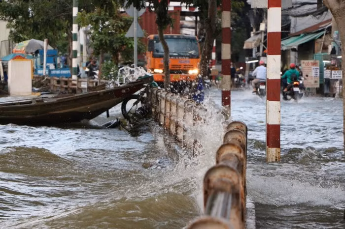 Theo ghi nhận của PV Báo Giao thông, từ hơn 16h30 nước dâng lên rất cao, tràn ra đường, ô tô, container chạy băng qua dòng nước tạo các con sóng lớn đánh vào bờ, một số người bị té ngã do sóng đánh mạnh.