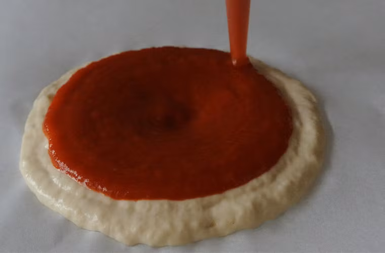 ...sau đó là in nước sốtpizza. Tuy miếng bánh pizza thành phẩm vẫn sẽ phải hấp trong lò, nhưng các phiên bản sau của máy in Foodini có thể nấu được thức ăn.