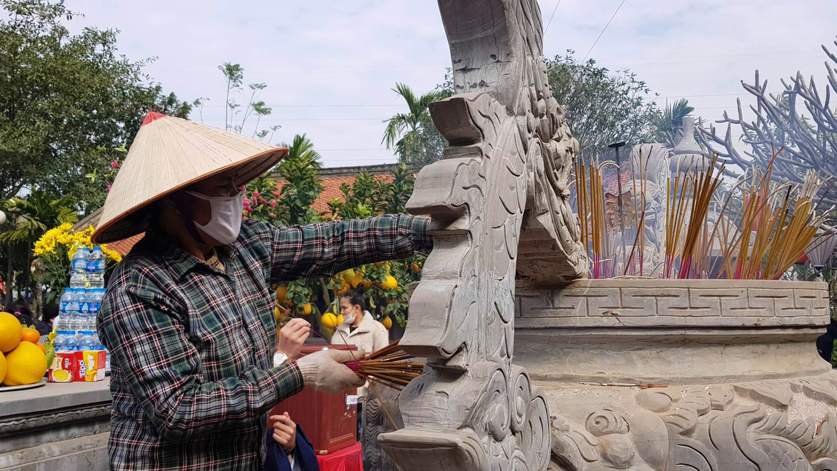 Nhiều du khách thắp nhiều nhang hơn so với quy định khiến Ban quản lý đền phải cử người liên tục rút nhang.