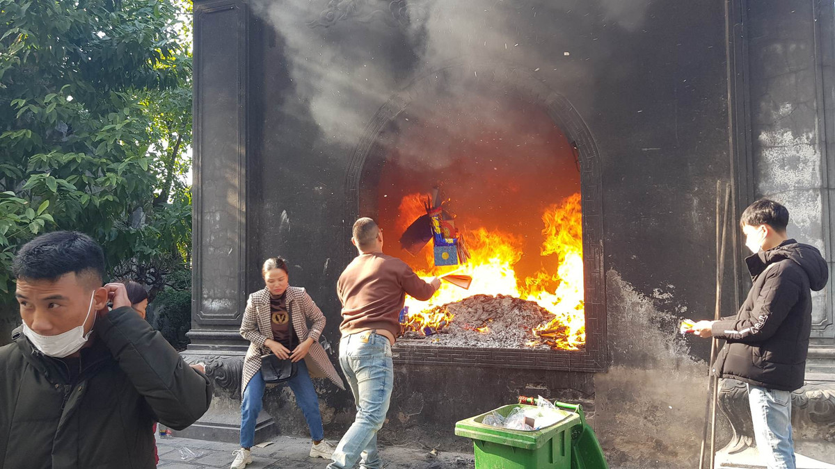 Một du khách đốt vàng mã sau khi thắp hương dâng lễ.