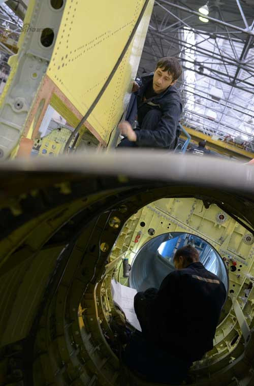 Một thợ kĩ thuật đang ngồi đọc bản thiết kế trong khoang động cơ.